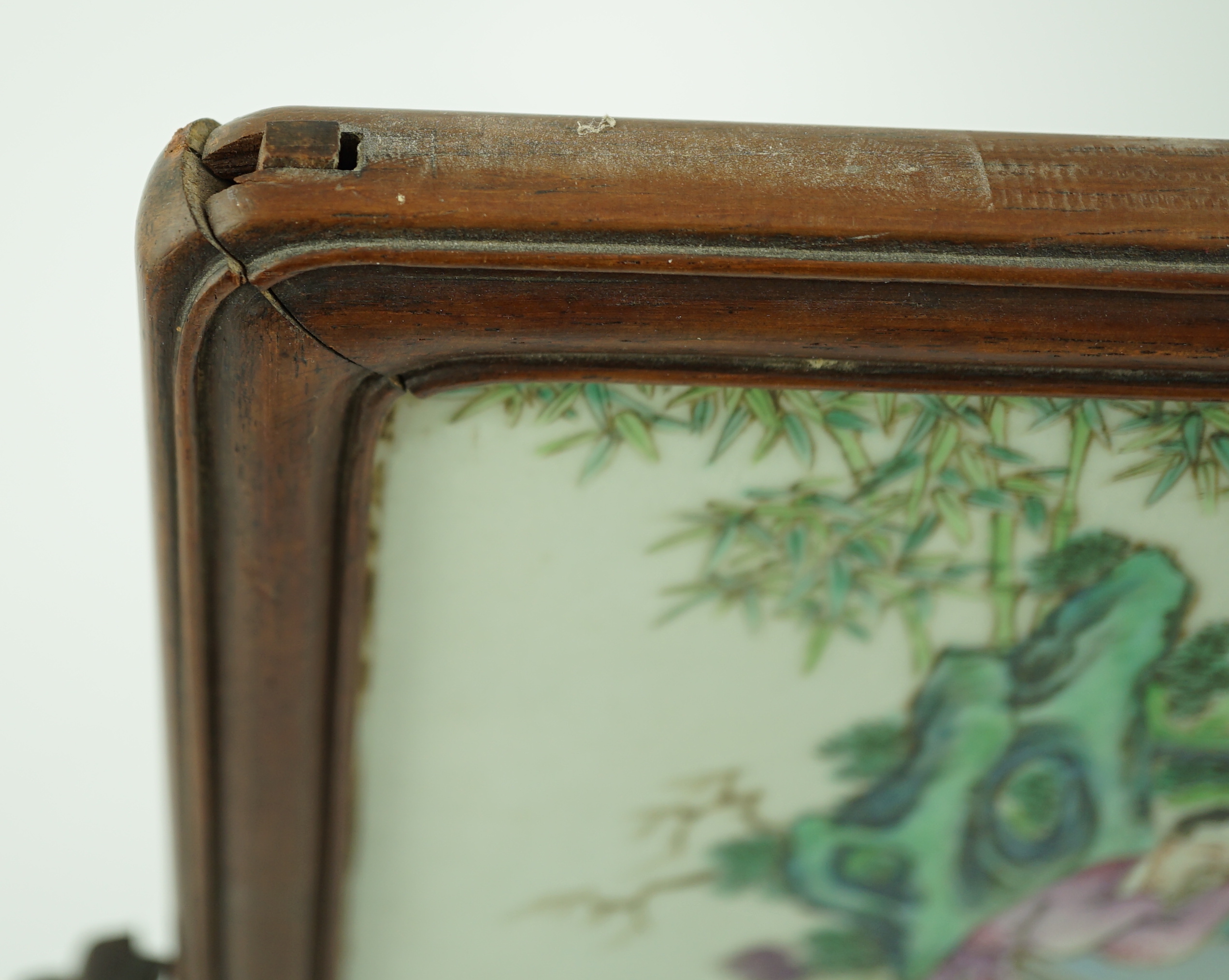 A Chinese famille rose porcelain mounted hongmu framed table screen, 19th century, some damage
